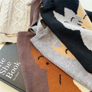 Gros plan de sacs cabas en maille épaisse montrant des motifs de chat et des textures