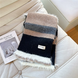 Close-up of striped knit scarf with handmade fashion tag and white plush trim
