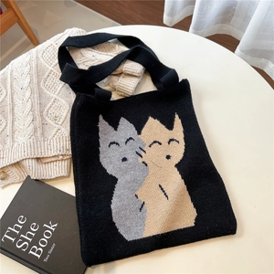Vue à plat montrant la texture du sac cabas tricoté noir avec motifs chats mignons