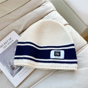 Detailed close-up of striped knit beanie texture with woven logo tag on fabric