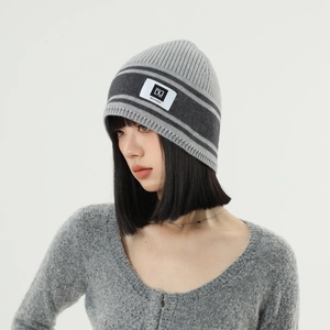 Close-up of grey striped knit beanie with DQ Men's Wear logo patch on the front cuff