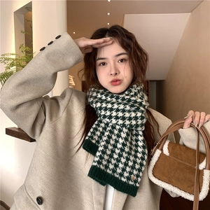 Detail of green houndstooth knit scarf texture with ribbed edges on a stylish beige coat