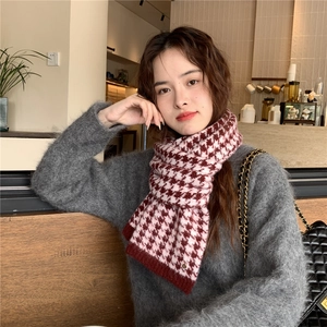 Detail of red and white houndstooth knit scarf showing thick texture and ribbed edges