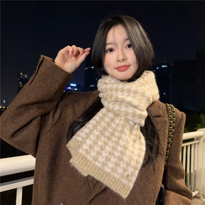 Close-up of soft beige and cream houndstooth knit scarf with detailed woven texture