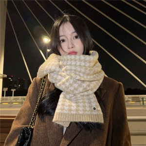 Detailed knit texture of beige houndstooth scarf paired with a wool coat and chain bag