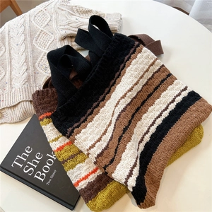 Detail of multi-color striped knitted tote bag showing thick texture and woven handle
