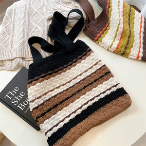 Detailed close-up of striped knit tote bag with bohemian texture on a white table