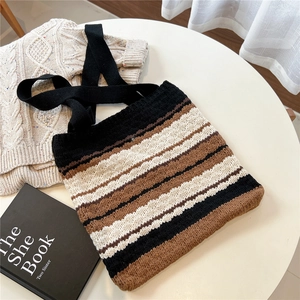 Close-up of striped knit tote bag with thick texture in black, cream and brown