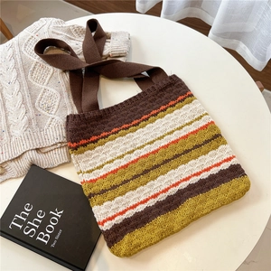 Detail of colorful striped knit tote bag showing thick yarn texture and wide strap