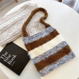 Détail d'un sac cabas en maille rayée avec texture pelucheuse et rayures marron chaudes