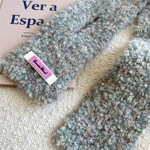 Nahaufnahme von weichem Mohair-Strickschal mit flauschiger Textur und lila Logo-Etikett