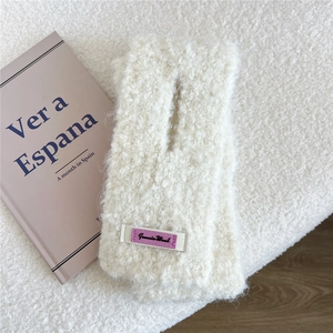 Detail der cremeweißen Fleece-Halswärmer mit lila Woll-Label für warme Wintertage