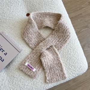 Detailaufnahme des beigen Bouclé-Strickschals mit gewebtem Jennie Wool Etikett