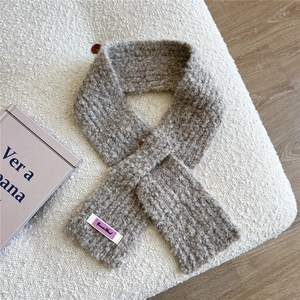 Detailansicht eines taupefarbenen Strickschals mit strukturierter Bouclé-Oberfläche