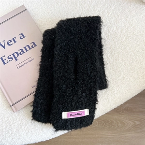 Nahaufnahme schwarzer flauschiger fingerloser Handschuhe mit weißem Webetikett