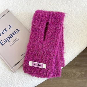 Details des pflaumenfarbenen Strickschals mit Jeanie Wool Etikett und weicher Textur