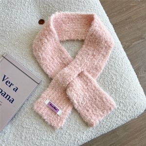 Detailansicht eines weichen rosa Strickschals mit dekorativem Etikett für den Winter