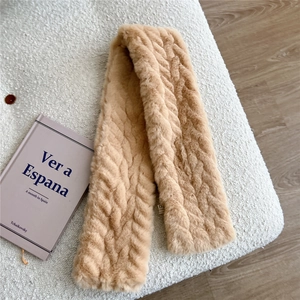 Detail of light camel faux fur scarf showing herringbone texture and a small woven label