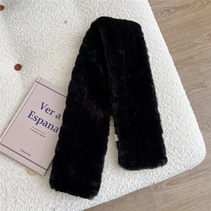Close-up of black faux fur neck warmer with brand label on white tweed texture