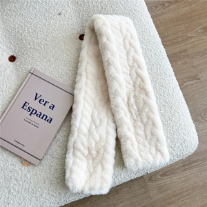Detail of cream plush scarf with textured knit pattern on a soft background
