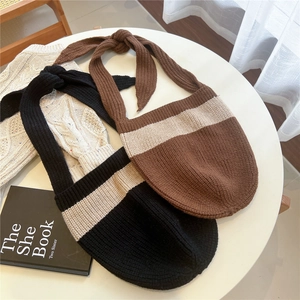 Knitted striped shoulder bags with oversized knot straps in black and brown colors