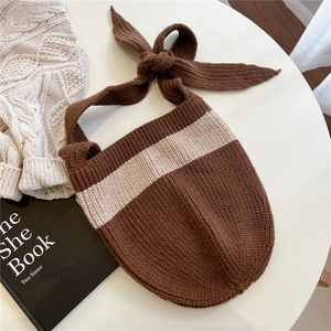 Close-up of brown striped knit tote bag with a decorative knotted shoulder strap