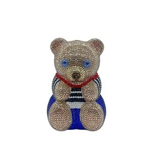 Détail macro de la pochette ours de luxe avec incrustations de cristaux champagne