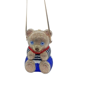 Vue détaillée du sac de soirée ours de luxe avec cristaux étincelants et nœud en soie rouge