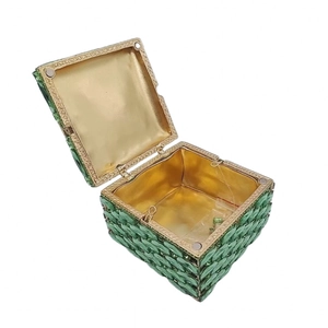 Macro view of emerald crystal clutch bag with gold lining and magnetic clasp detail