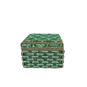 Detail of green faceted crystal jewelry box with woven texture and gold metal frame