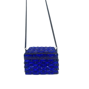 Detailed close-up of dark blue crystal lattice pattern and metallic chain on clutch bag