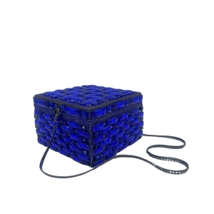 Detail of royal blue square clutch with geometric crystal pattern and gray metal chain