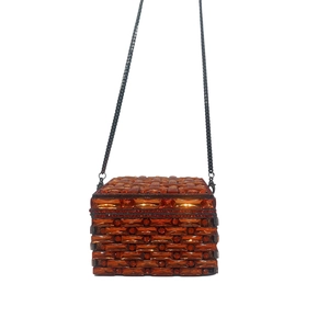 Macro detail of orange crystal evening clutch with square amber gemstone grid pattern