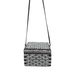 Macro shot of cubic evening clutch featuring rectangular crystals and black chain strap