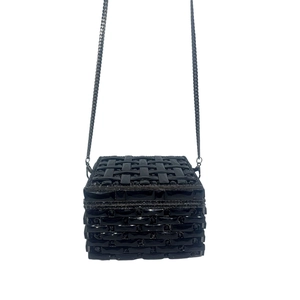 Close-up of black cube evening clutch with 3D woven texture and metallic chain strap