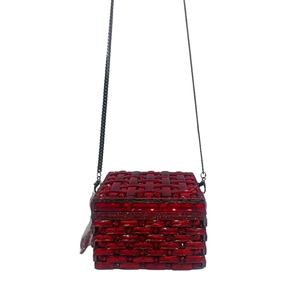 Macro detail of red crystal encrusted clutch bag with elegant woven texture pattern