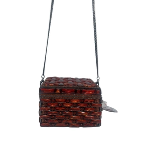 Close-up of rectangular amber crystal evening clutch with intricate woven pattern and metal chain