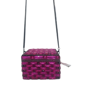 Macro detail of magenta crystal clutch bag with woven rhinestone pattern and metal chain