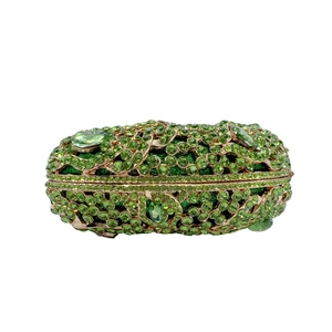 Detailed view of luxury grass green rhinestone clutch bag with emerald gemstones