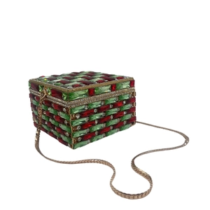 Detail of crystal clutch bag with red and green rhinestones and golden snake chain