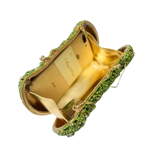 Macro detail of open rhinestone clutch bag interior showing space for a smartphone