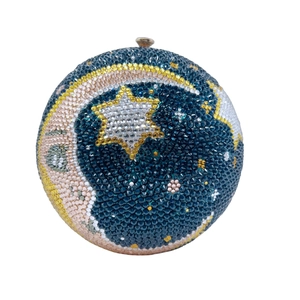 Detailed macro view of the moon and stars rhinestone pattern on this round evening clutch