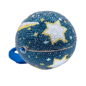 Detail of spherical clutch bag with blue rhinestones star pattern and silk tassel