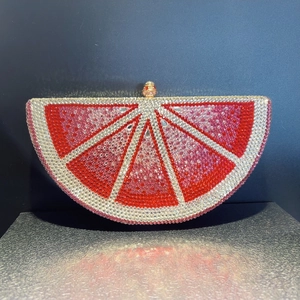 Macro detail of grapefruit slice crystal clutch with hand-set red and pink rhinestones