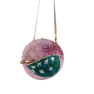 Macro detail of apple-shaped evening clutch with pink crystals and green leaf design