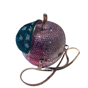 Detailed view of apple-shaped luxury evening clutch with pink gradient rhinestones and green leaf