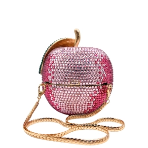 Macro shot of luxury apple clutch featuring pink rhinestones and a gold metal leaf detail