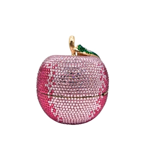 Macro shot of luxury apple clutch with gradient pink crystals and gold leaf stem detail