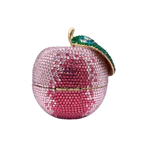 Macro shot of luxury apple-shaped clutch featuring pink crystal pavé and gold leaf detail