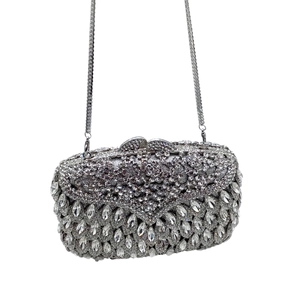 Detailed close-up of luxurious silver evening bag with teardrop rhinestones and chain